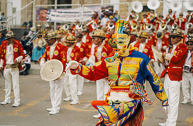 Kostümierter Teilnehmer und Musiker bei der Parade zum Karneval von Oruro