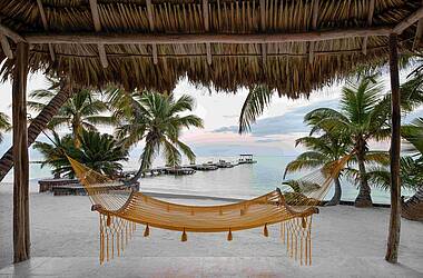 Hängematte mit dem Steg des Matachica Resort in Belize im Hintergrund
