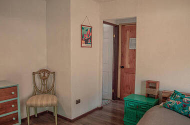 Kommode, Stuhl, Nachttisch und Bett in einem Zimmer im Eco-Hostal Tambo Verde