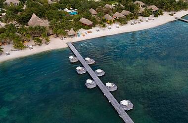 Steg des Matachica Resort über dem blauen Wasser des Karibischen Meers vor Ambergris Caye von oben